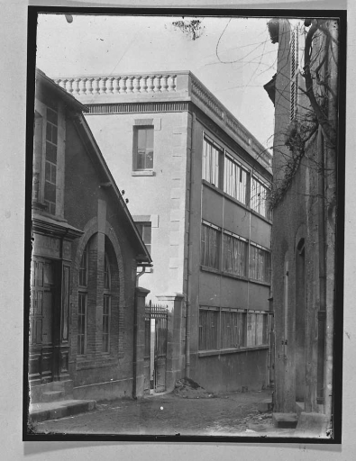 Vue, depuis la rue Feydeau, des ateliers de cartonniers, à gauche, et de tapissiers, à droite, construits respectivement en 1904 et 1914. Le bâtiment de droite a été démoli vers 1970. Photographie réalisée dans la première moitié du 20e siècle.