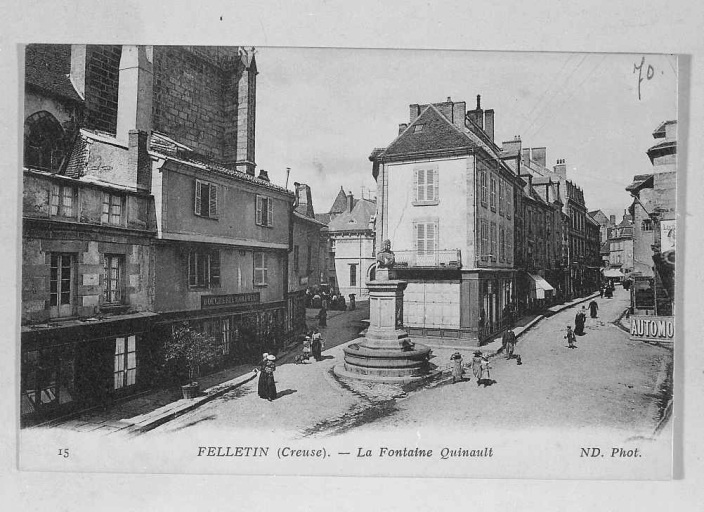 Grande Rue. Vue prise depuis le sud et montrant la rue au niveau de la place Quinault et son tronçon situé entre cette place et la place Courtaud (côté impair). Sur cette vue sont visibles deux maisons, aujourd'hui démolies, accolées à la maison rénovée abritant l'office du tourisme (n° 26).