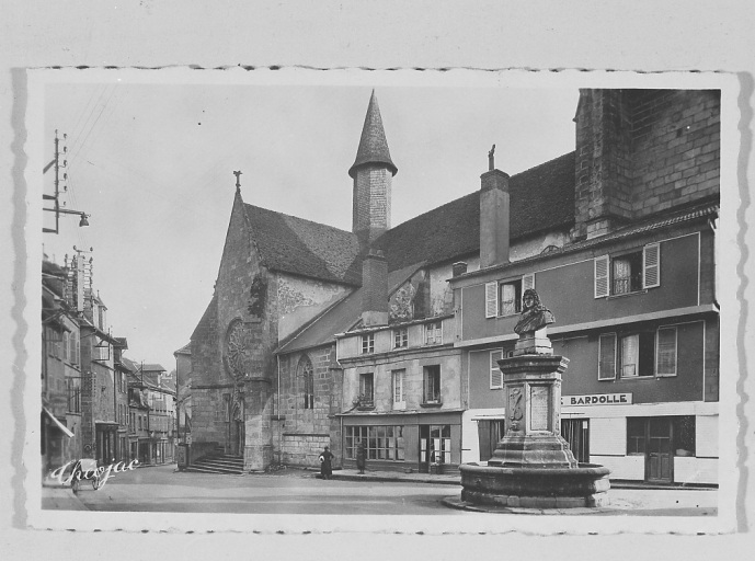 Grande Rue. Vue prise depuis la place Quinault et montrant, au premier plan, la fontaine Quinault et deux maisons accolées à l'église du Moutier (la maison située, à gauche a été démolie et l'autre, ancienne boucherie Bardolle a été restaurée et abrite actuellement l'office du tourisme).