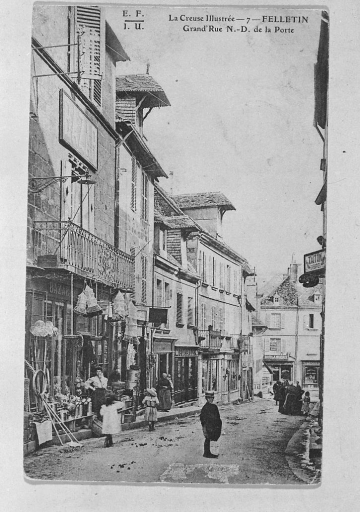 Grande Rue (appelée autrefois : Grande Rue Notre Dame de la Porte). Vue partielle, depuis le nord, montrant le tronçon de rue compris entre la fontaine Quinault et le carrefour de la Grande Rue et de la rue Grancher ; au premier plan, à gauche est visible la maison abritant au rez-de-chaussée le 'Bazar de la ménagère' (n° 35 actuel).