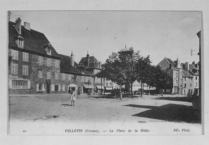 Vue d'ensemble de la place, prise depuis le nord et montrant sa partie centrale plantée d'arbres et la halle.