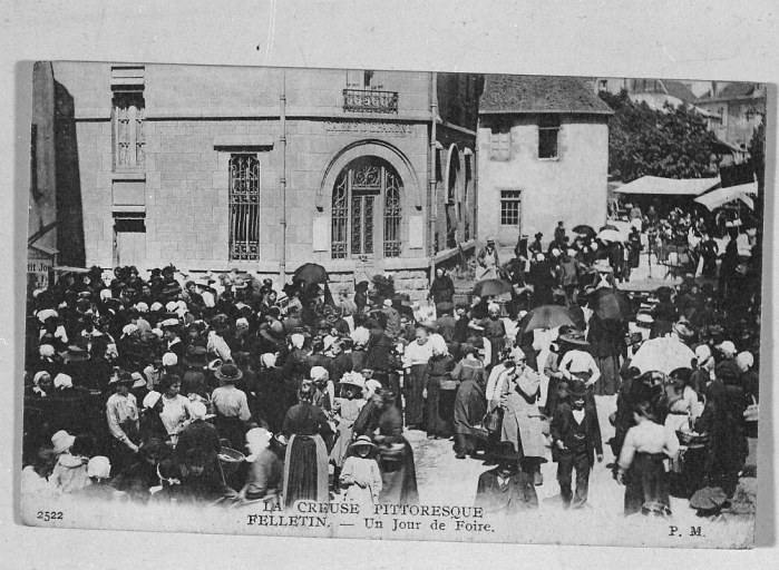 Rue du Clocher. Vue de la rue montrant l'ambiance d'un jour de foire avec la foule massée devant la Caisse d'Epargne. Cette vue a été faite après 1904 (date de construction de la Caisse d'Epargne).