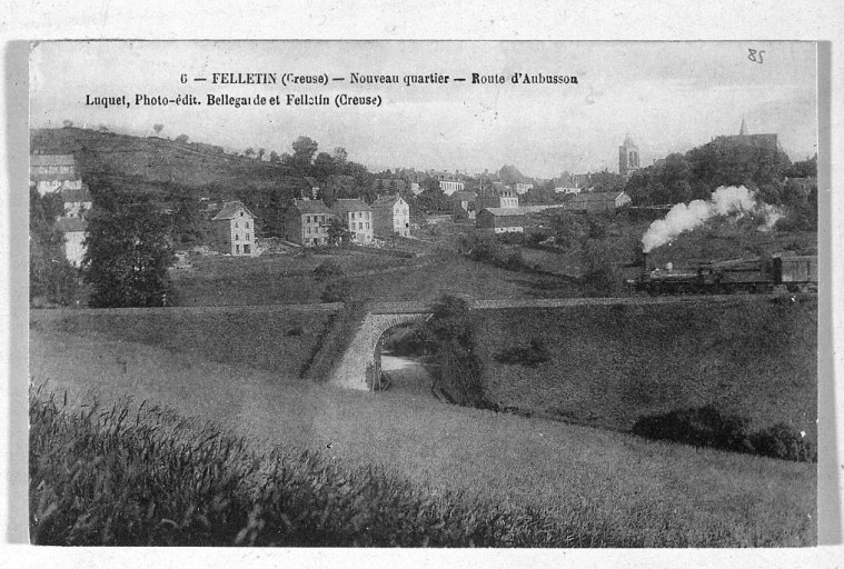 Vue d'ensemble prise depuis le nord-ouest, montrant au premier plan, la route de Vallières, le pont de chemin de fer qui la surplombe et à l'arrière-plan, la route d'Aubusson.