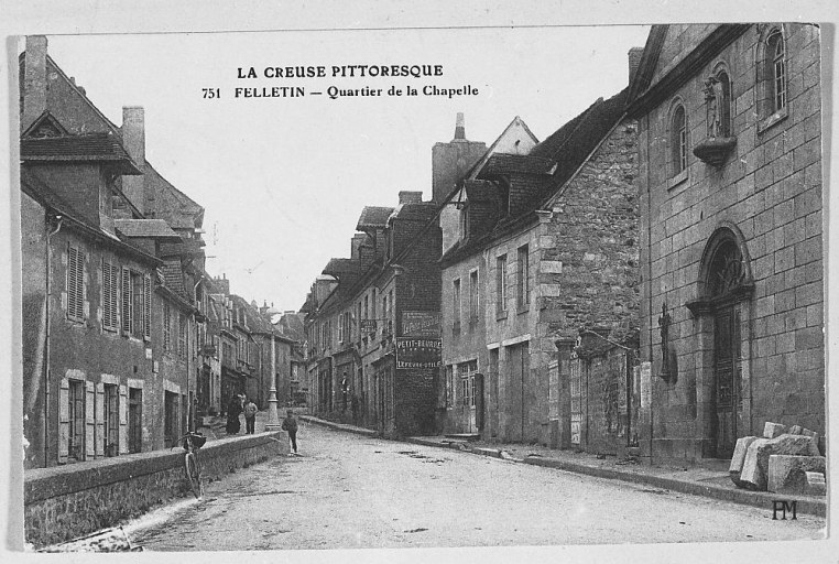 Rue Grancher. Vue, depuis la route de Tulle, d'une partie de la rue, montrant l'enfilade de maisons avec toiture dotées de lucarnes.