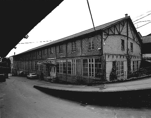 Les ateliers reconstruits entre 1927 et 1931, surmontés du séchoir de 1946 : vue prise nord, depuis l'ancien hangar à bois, actuel théâtre Expression 7. Au premier plan, la rampe d'accès au séchoir.