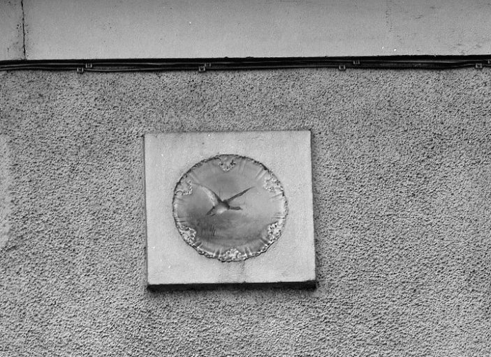 Assiette de porcelaine (motif d'oiseau) à l'angle ouest de la façade.