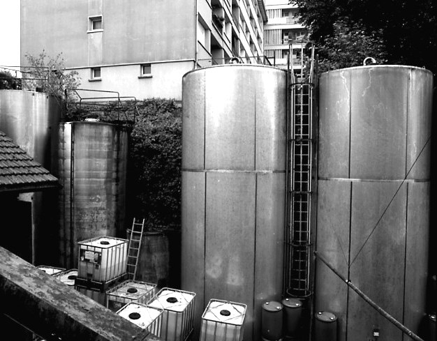 Cour de l'usine vue du premier étage de l'atelier de fabrication : cuves de stockage.