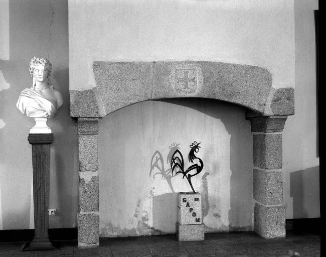 Rez-de-chaussée, salle orientée au sud et à l'ouest. Vue de la cheminée en pierre ornée d'un blason.