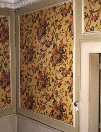 Premier étage. Pièce ornée de papier peint aux motifs floraux (corbeilles et bouquets de fleurs). Vue d'un panneau représentant des corbeilles de fleurs accrochées à des branches par des rubans.