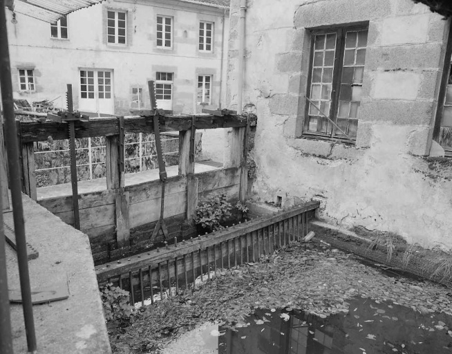 Vue du bief, la vanne du canal d'amenée. Au fond, le bâtiment portant la date de 1846.