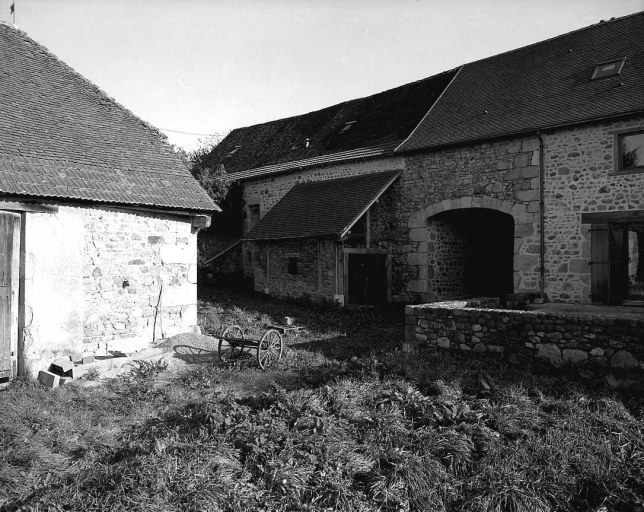 Vue, depuis la cour, de la grange étable, de type auvergnat, accolée au logis et de son passage couvert.