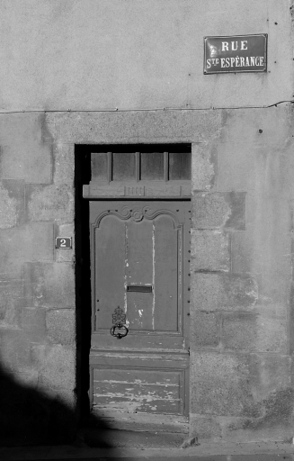 2 rue Sainte-Espérance. Maison (AL 456). Vue de détail de l'élévation antérieure montrant la porte. Cette porte, à un seul vantail orné d'une mouluration chantournée rehaussée d'un motif floral, a conservé son heurtoir.