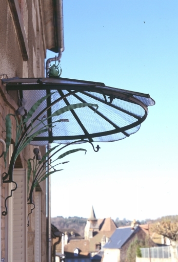 2 rue de Beaumont. Maison (AM 72, 73). Vue de détail d'une marquise dont les montants latéraux en fer sont ornés de motifs végétaux (feuilles et fleurs d'iris).