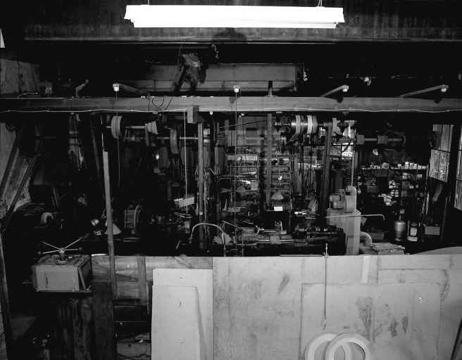 L'atelier de mécanique générale : enchevêtrement de courroies et machines-outils.