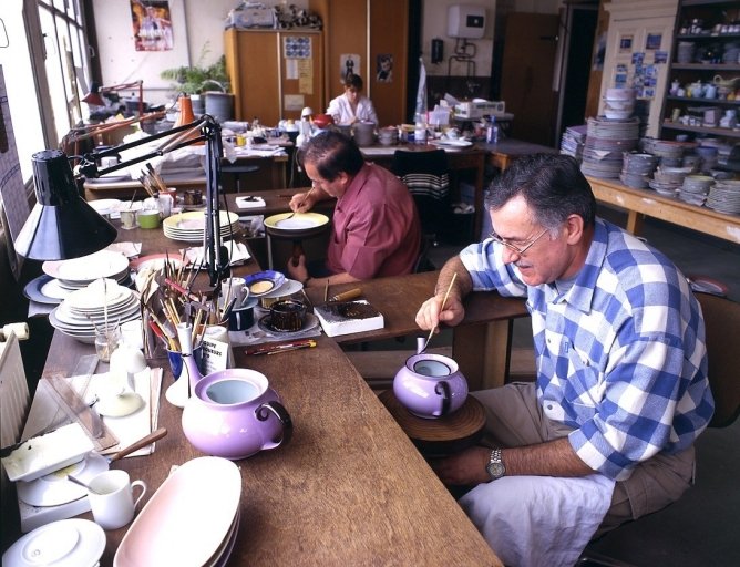 L'atelier de peinture : au premier plan, le peintre applique un filet d'or mat.