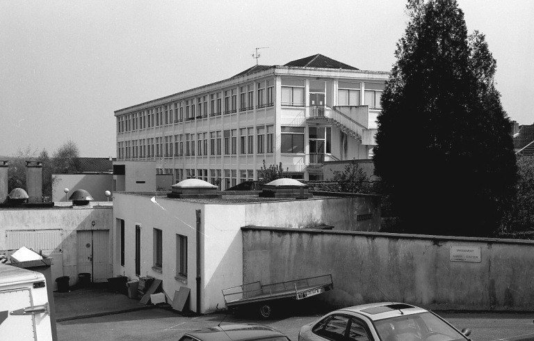 Façade postérieure et pignon ouest des ateliers construits en 1917-1919. On distingue la toiture des bureaux.