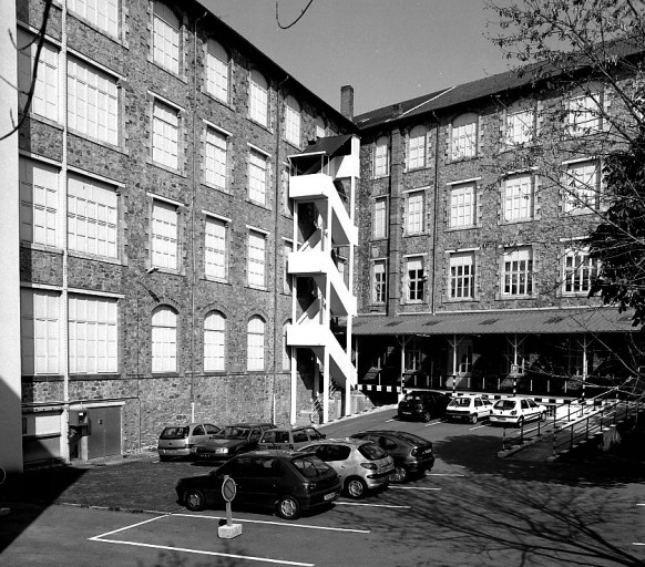 Vue de l'usine depuis la cour intérieure (sud-est) : les ailes sud (à gauche) et nord (à droite) de l'usine.