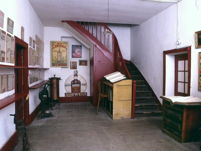 Hall d'entrée de la distillerie, transformé en musée : registres anciens, matériel, affiches, papiers à en-tête de diverses distilleries de Limoges.