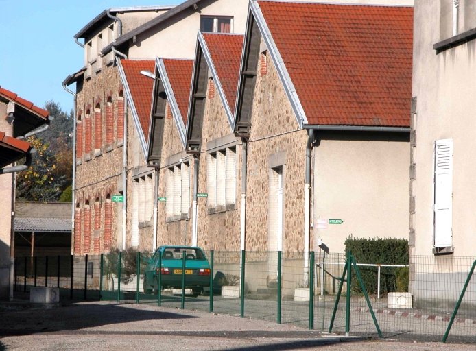 Vue d'anciens ateliers de fabrication (ateliers couverts de sheds) et des bâtiments des fours (?).
