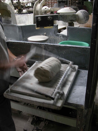 Table de découpe : le cadre, où sont tendus des fils métalliques, est abaissé sur le rondin.