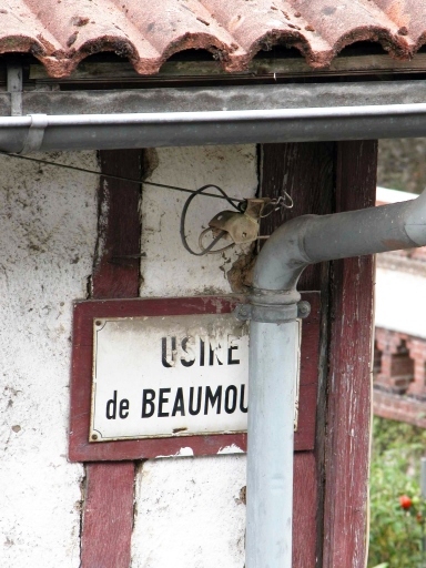 Plaque émaillée portant l'inscription 'Usine de Beaumoulin', à l'angle sud-ouest du bâtiment ouest des anciens ateliers de la forge, puis de l'usine de porcelaine puis de la mégisserie.