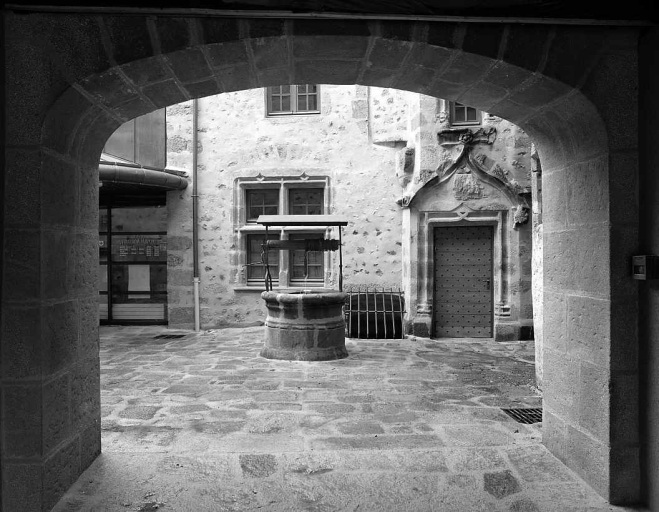 Vue, après restauration, depuis la place Courtaud, montrant une partie du rez-de-chaussée de l'élévation sur cour (ouverture d'accès à la cave, fenêtre à meneau et porte de la tour d'escalier) ; est visible également le puits autrefois vraisemblablement commun à l'ensemble des demeures entourant la cour.