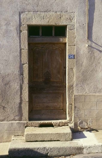 36 Rue Sainte-Espérance. Maison (cadastre AL 417). Vue de détail de l'élévation antérieure montrant la porte d'entrée. Le linteau porte une date et un monogramme gravés : 'J 1808 D' ; le vantail à la mouluration chantournée, rehaussée d'un motif floral, a conservé son heurtoir.