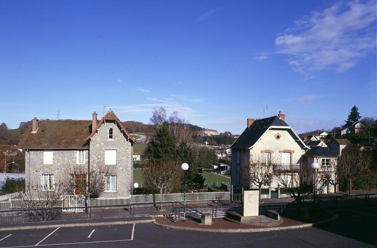 Vue partielle de la place Monthioux et de son aménagement (stèle sculptée en pierre érigée entre deux escaliers descendant sur l'avenue de la Gare).