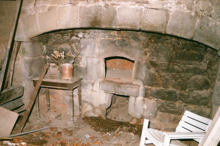 Bâtiment nord donnant sur le jardin régulier et abritant une grange, une étable et un logement. Vue d'une cheminée avec une entrée de four à pain.