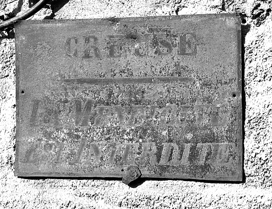 Plaque fixée sur une maison de la rue Grancher (n° 30, AL 457) et mentionnant que 'la mendicité est interdite'.