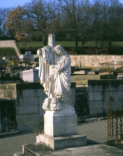 Tombe surmontée d'une stèle sculptée en ronde bosse et représentant une figure féminine éplorée adossée à une croix écotée. Vue d'ensemble de la stèle.