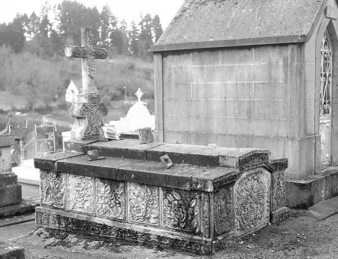 Monument sépulcral réalisé en ciment armé et orné d'un décor floral.