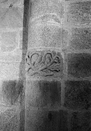 Colonne sud de la nef entre la première et deuxième travée. Vue montrant un décor en bas-relief représentant des feuilles de chêne avec glands et sculpté sur l'une des pierres du fût.