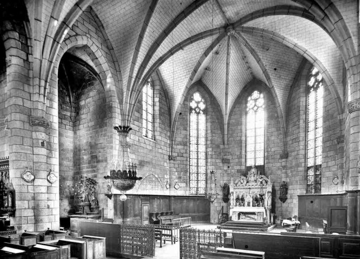 Vue partielle de l'église prise au début du 20e siècle et montrant le choeur et la chapelle latérale nord de la troisième travée. Cette vue montre notamment le mobilier de la chapelle latérale nord : autel en bois avec tabernacle et gradins sur lequel reposent une statue difficilement reconnaissable (Sacré-Coeur ou saint Joseph) et une statue en plâtre polychrome (sainte Thérèse d'Avila ?) aujourd'hui déposée dans le grenier de la mairie actuelle.