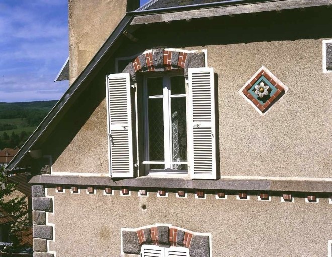 19 route de Crocq. Maison (AM 126). Vue de détail d'un motif en céramique ornant l'élévation est.