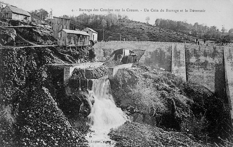 Le barrage en cours de surélévation avec détail du déversoir et des baraques de chantier.