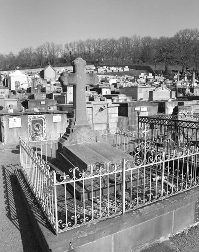 Tombe (n° 11). Tombe en pierre de Volvic surmontée d'une croix ; la sculpture de sa partie supérieure simule un livre ouvert. Vue d'ensemble.