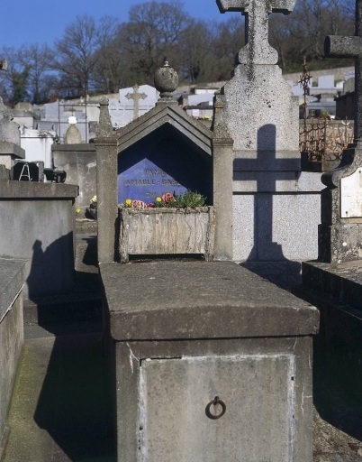 Tombe (n° 18). Tombe en ciment surmontée d'une niche peinte en bleue qui abrite une jardinière en ciment armé traité à la manière des rocailleurs.