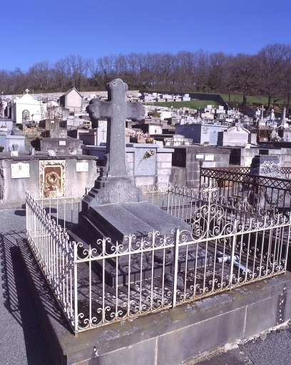 Tombe (n° 11). Tombe en pierre de Volvic surmontée d'une croix ; la sculpture de sa partie supérieure simule un livre ouvert. Vue d'ensemble.