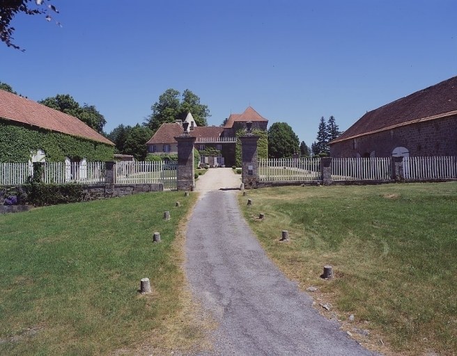 Vue d'ensemble prise depuis l'ouest montrant le portail d'entrée, les bâtiments disposés de part et d'autre du jardin régulier et le château au fond.