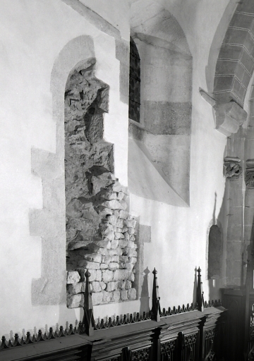 Choeur. Vue partielle du mur sud montrant les vestiges d'encadrement d'une ancienne baie, gardée comme vestige archéologique au moment de la restauration de l'église.