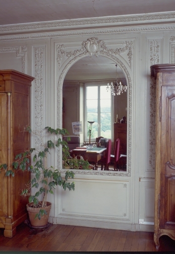 Intérieur, rez-de-chaussée. Vue partielle de l'ancien salon montrant le mur est orné de lambris de revêtement et d'un miroir d'applique.