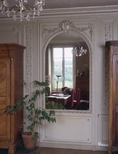 Intérieur, rez-de-chaussée. Vue partielle de l'ancien salon montrant le mur est orné de lambris de revêtement et d'un miroir d'applique.