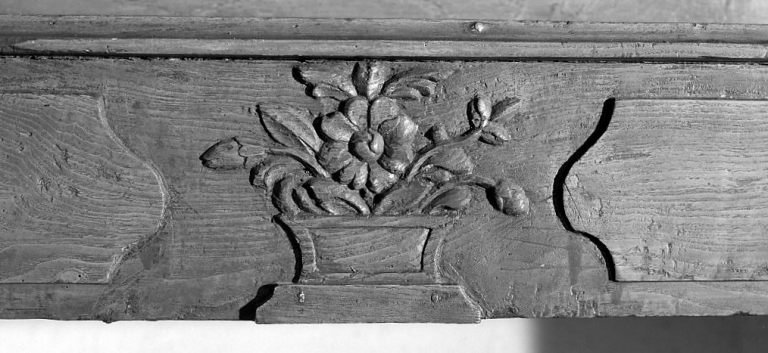 Premier étage, pièce sud-ouest. Cheminée, détail du motif sculpté ornant la partie centrale du manteau et représentant un bouquet de fleurs.
