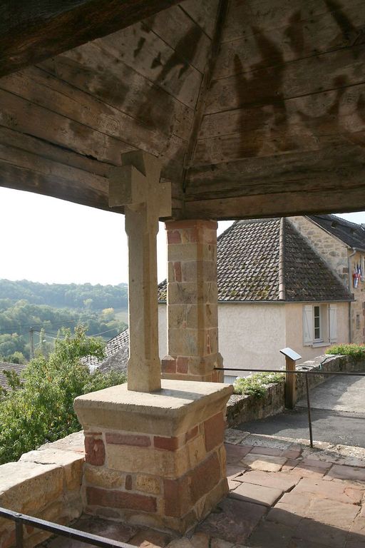 Croix monumentale pattée en pierre, érigée sur un socle maçonné.