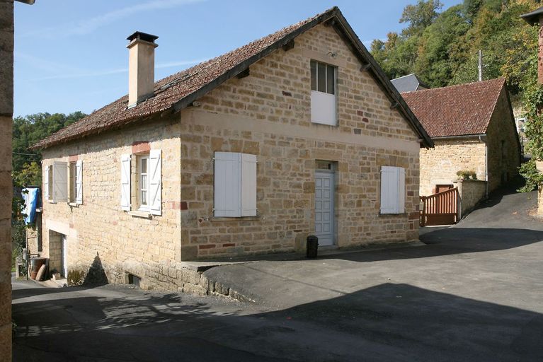 Vue générale de la composition du mur-pignon nord-est : une porte piètonne accostée de deux fenêtres droites et surmontée d'une porte fenêtre éclairant l'étage de comble.