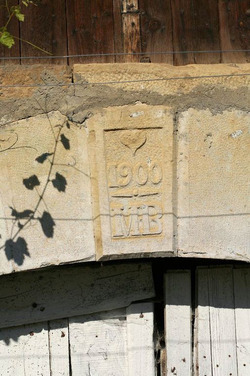 Clé de la porte de la grange portant la date 1900 surmontée d'un coeur  et les initiales M.B.