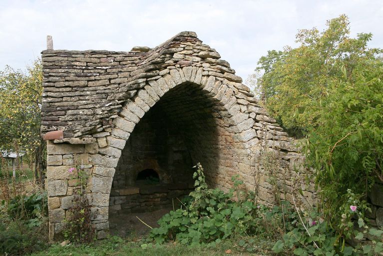 Fournil coiffé d'un toit en double bâtière, couvert de lauzes de calcaire montées en tas-de-charge. ; Les Treilles. Fournil coiffé d'un toit en double bâtière, couvert de lauzes de calcaire montées en tas-de-charge.
