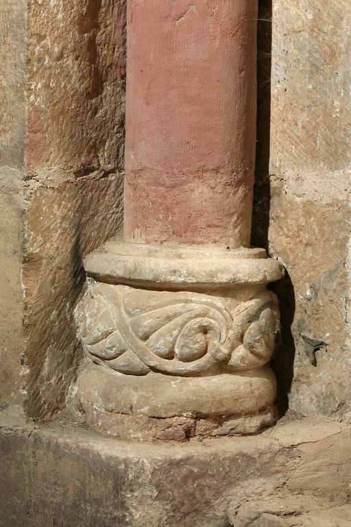 Baie axiale du chevet. Détail de la base sculptée de la colonnette de gauche présentant un décor de rinceaux.