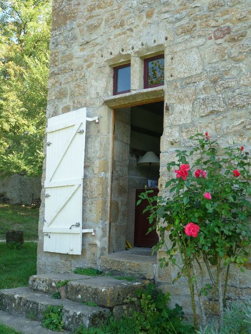 Mur de croupe ouest. Porte piétonne décentrée à imposte vitrée surmontée d'une double accolade (en remploi).